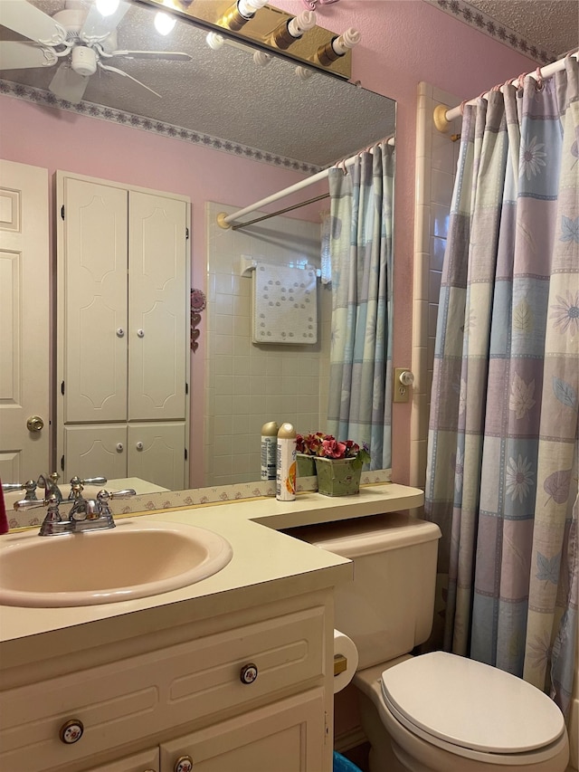 bathroom with vanity, toilet, a textured ceiling, and ceiling fan