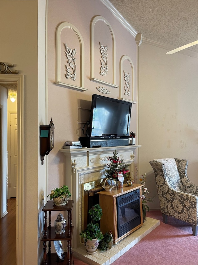 living room with a textured ceiling, a brick fireplace, hardwood / wood-style flooring, and ornamental molding