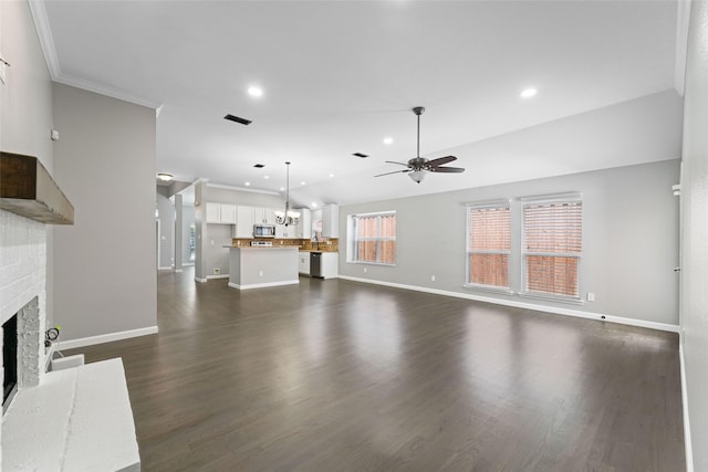 unfurnished living room with a brick fireplace, dark hardwood / wood-style flooring, ornamental molding, and ceiling fan