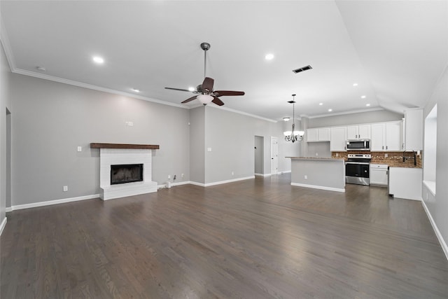 unfurnished living room with crown molding, a fireplace, dark wood-type flooring, ceiling fan with notable chandelier, and lofted ceiling