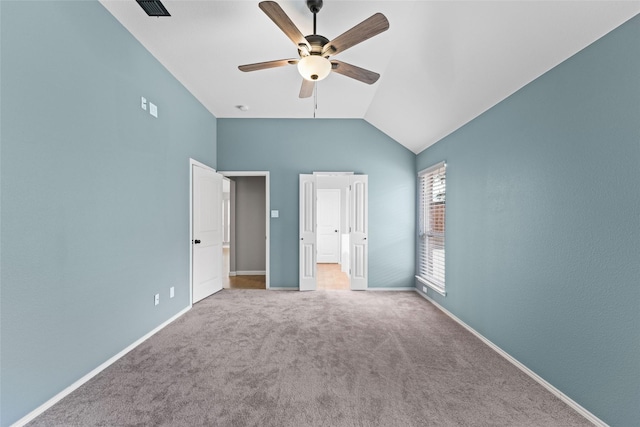 unfurnished bedroom with ceiling fan, vaulted ceiling, and carpet flooring