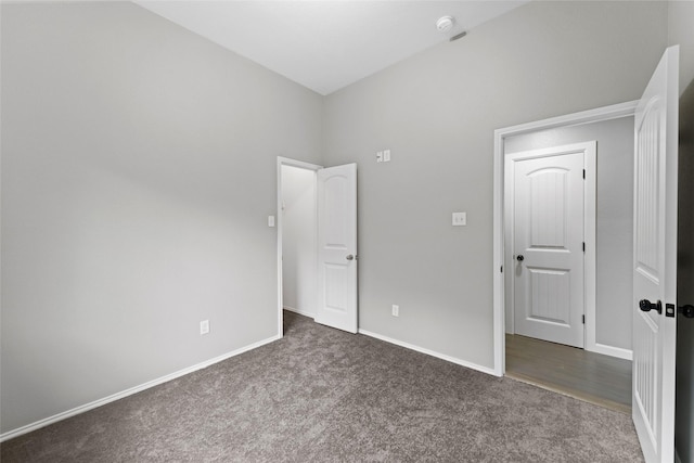 unfurnished bedroom with dark carpet