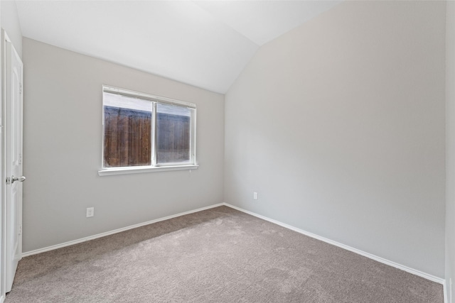 carpeted empty room featuring lofted ceiling