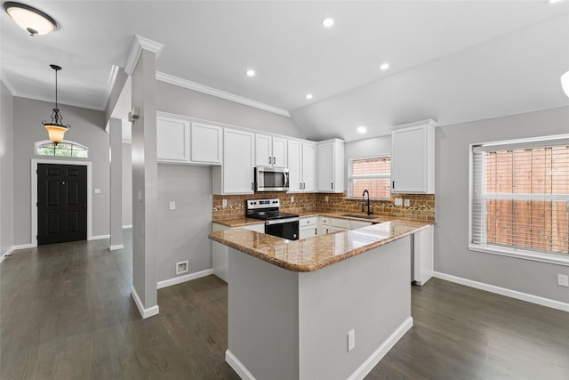 kitchen with pendant lighting, white cabinetry, appliances with stainless steel finishes, and lofted ceiling