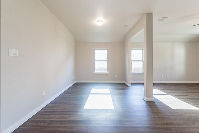 empty room featuring ceiling fan, vaulted ceiling, and dark hardwood / wood-style floors