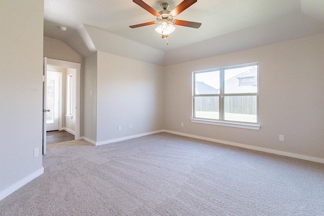 carpeted spare room with ceiling fan, a wealth of natural light, and lofted ceiling