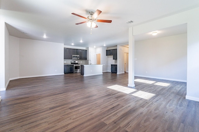 unfurnished living room with ceiling fan, dark hardwood / wood-style floors, and sink