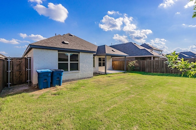 rear view of house with a patio area and a yard