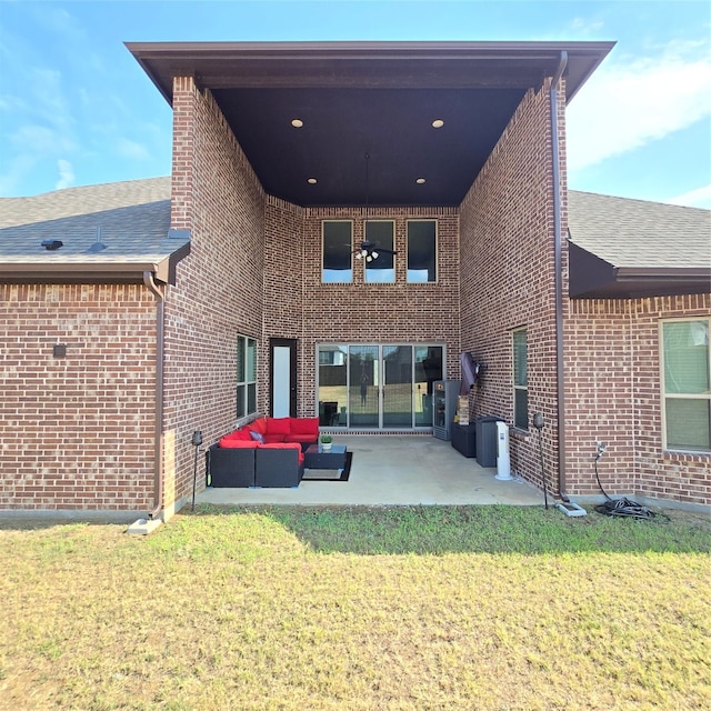 rear view of property featuring an outdoor living space, a patio area, and a lawn