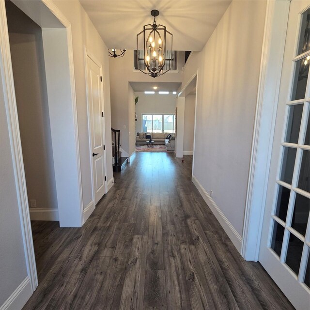 corridor featuring dark hardwood / wood-style flooring and a notable chandelier