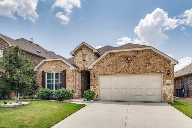 view of front facade with a garage, central AC unit, and a front yard