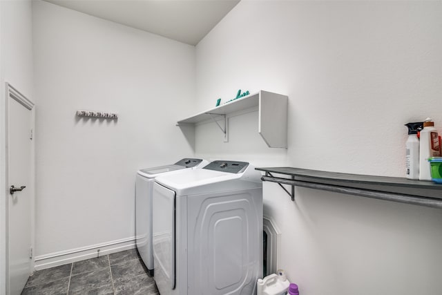 laundry area featuring dark tile patterned floors and washing machine and clothes dryer