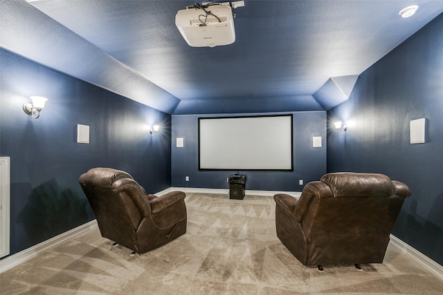 cinema room featuring vaulted ceiling and light colored carpet