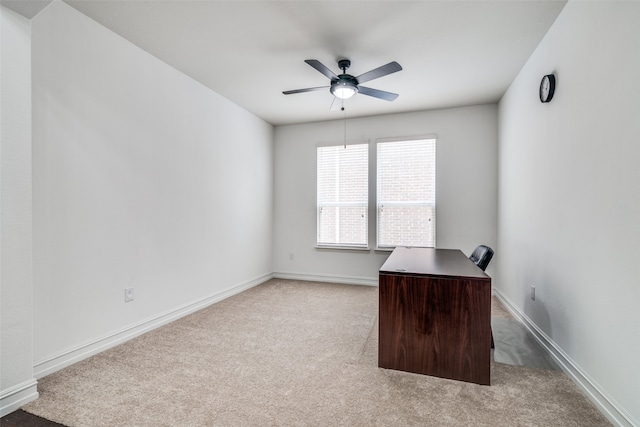 unfurnished office featuring light carpet and ceiling fan