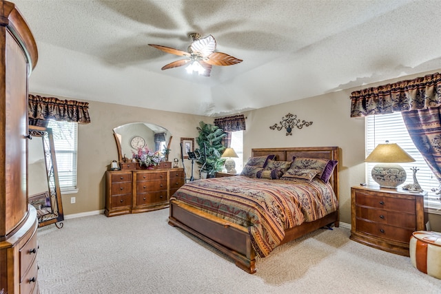 bedroom with a textured ceiling, ceiling fan, and light carpet