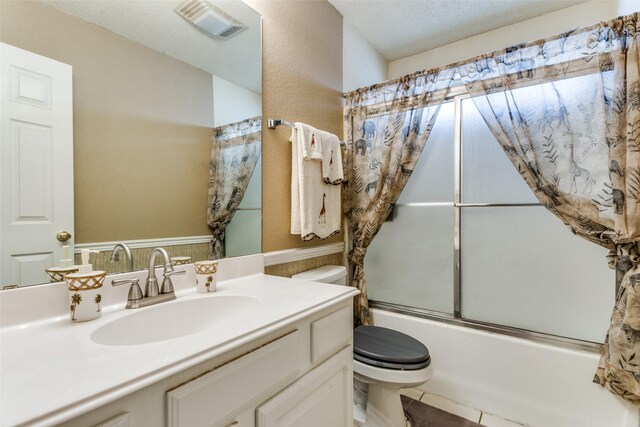 full bathroom featuring washtub / shower combination, toilet, tile patterned flooring, vanity, and a textured ceiling