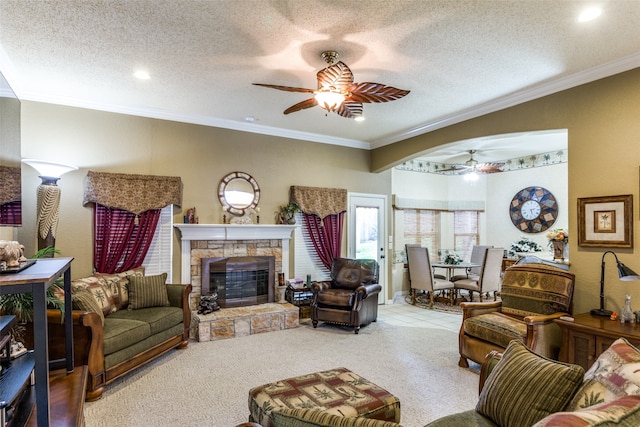 living room featuring ceiling fan, a textured ceiling, and a stone fireplace