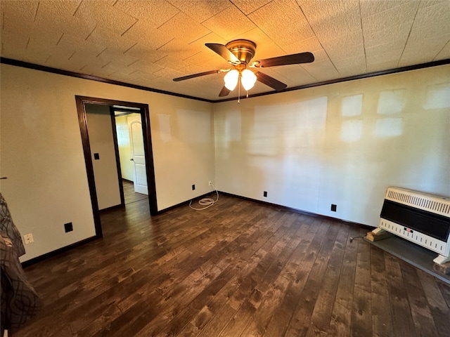 spare room with crown molding, heating unit, dark hardwood / wood-style floors, and ceiling fan