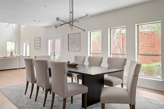 dining space featuring french doors, a notable chandelier, and light hardwood / wood-style floors