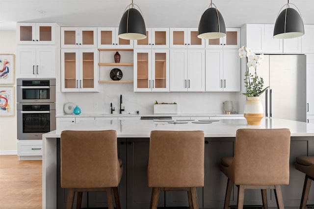 kitchen with white cabinets, pendant lighting, and appliances with stainless steel finishes