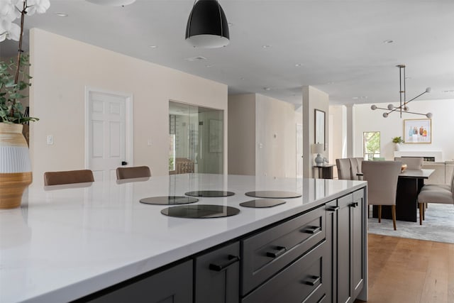 kitchen featuring light hardwood / wood-style floors, an inviting chandelier, and gray cabinets