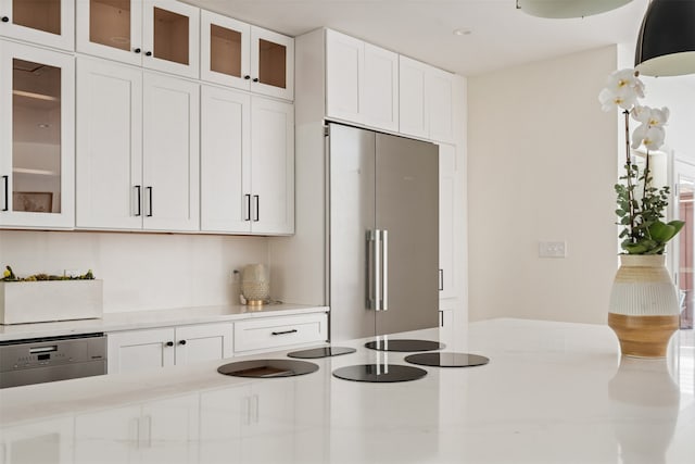 kitchen with built in refrigerator, dishwasher, white cabinets, and light stone counters