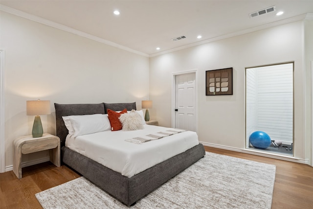 bedroom with crown molding and hardwood / wood-style floors