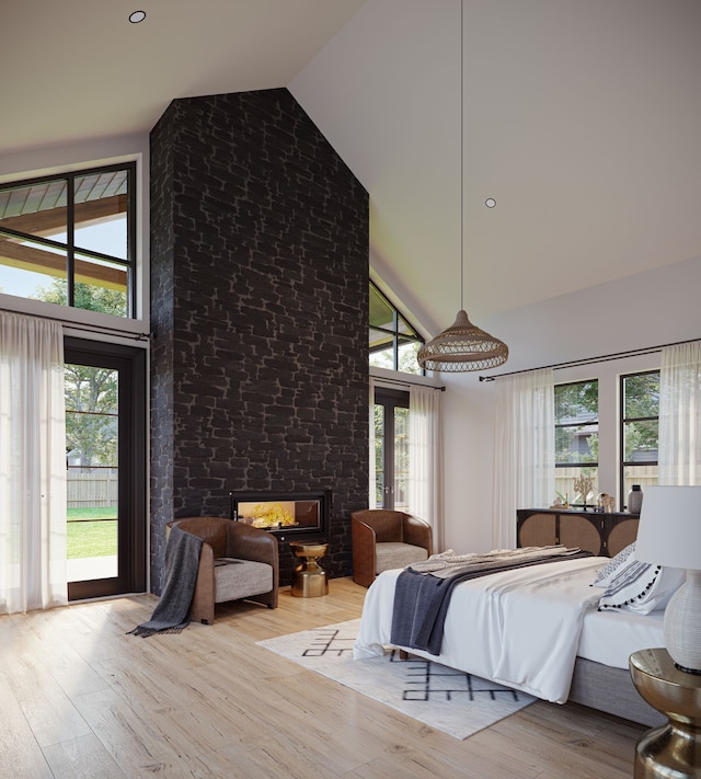 bedroom with high vaulted ceiling, a fireplace, access to exterior, and light wood-type flooring