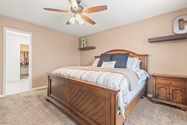 carpeted bedroom with a closet, ceiling fan, and a walk in closet