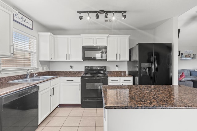 kitchen with sink, dark stone countertops, black appliances, and track lighting