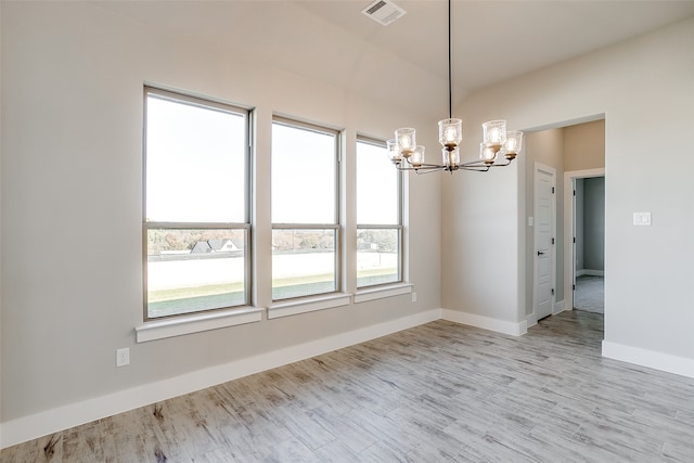 unfurnished dining area featuring a chandelier and light wood-type flooring