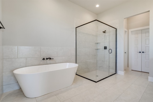 bathroom featuring separate shower and tub, tile patterned flooring, and tile walls