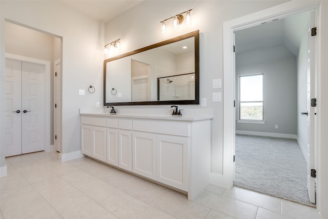 bathroom featuring tile patterned flooring, vanity, and a shower with shower door