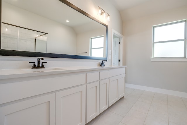 bathroom with tile patterned flooring, vanity, and vaulted ceiling