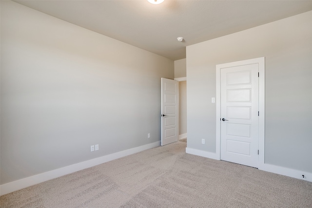 unfurnished bedroom featuring a closet and light colored carpet