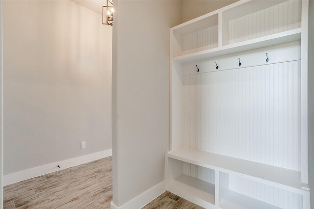 mudroom with hardwood / wood-style floors and a chandelier