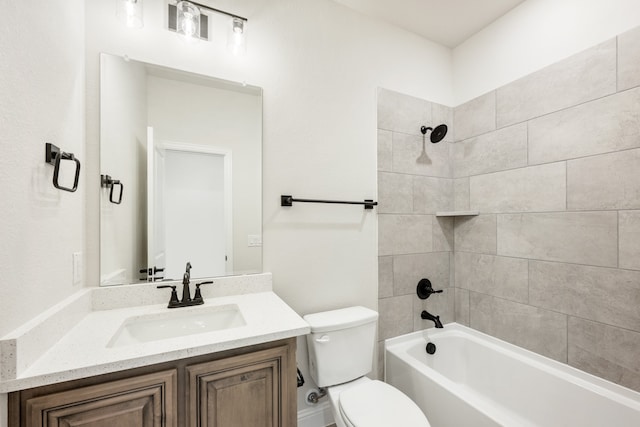 full bathroom featuring vanity, tiled shower / bath combo, and toilet