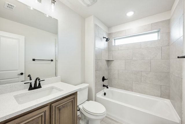 full bathroom featuring tile patterned flooring, vanity, tiled shower / bath combo, and toilet