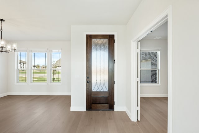 foyer with light hardwood / wood-style flooring and a notable chandelier