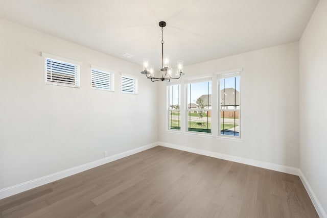 unfurnished room with a chandelier and hardwood / wood-style flooring