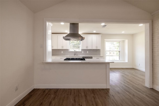 kitchen with white cabinetry, lofted ceiling, island range hood, and kitchen peninsula