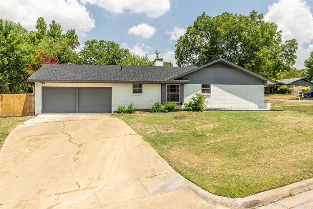 single story home featuring a garage and a front yard