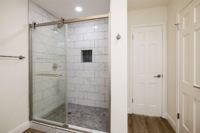 bathroom featuring wood-type flooring and a shower with shower door