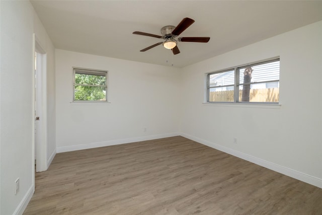 empty room featuring ceiling fan, light hardwood / wood-style flooring, and a wealth of natural light