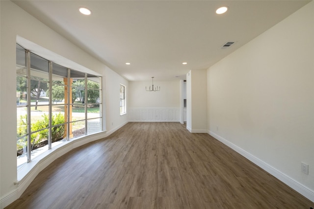 empty room featuring dark hardwood / wood-style floors and a chandelier