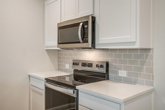 kitchen featuring tasteful backsplash, stainless steel appliances, and white cabinets