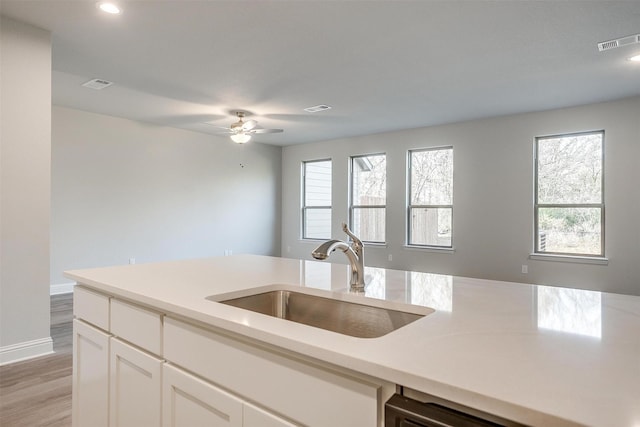 kitchen with sink, light hardwood / wood-style floors, white cabinets, and ceiling fan