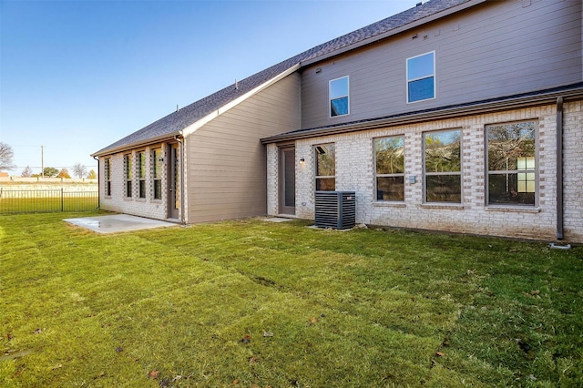 rear view of house featuring a yard, cooling unit, and a patio area