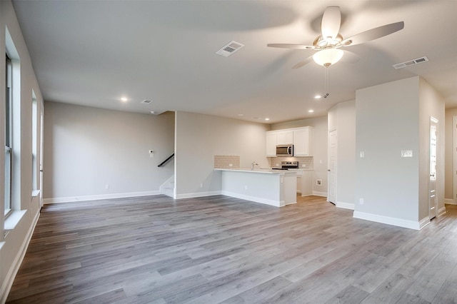 unfurnished living room with ceiling fan and light hardwood / wood-style flooring