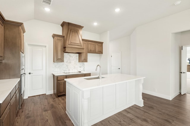 kitchen featuring sink, an island with sink, appliances with stainless steel finishes, dark hardwood / wood-style flooring, and custom range hood